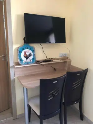 a desk with a computer monitor and two chairs at Cute Studio Apt, Pollo Resort in Sunny Beach