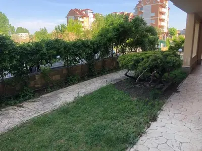 a garden with trees next to a fence at Cute Studio Apt, Pollo Resort in Sunny Beach