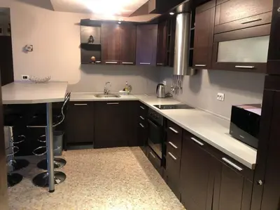 a kitchen with brown cabinets and a sink and a microwave at 2 Bed, Royal Beach Barcelo Hotel in Sunny Beach
