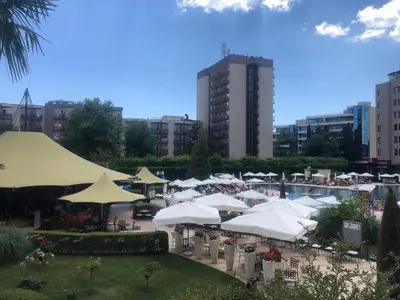 a group of white umbrellas and chairs and a pool at 2 Bed, Royal Beach Barcelo Hotel in Sunny Beach
