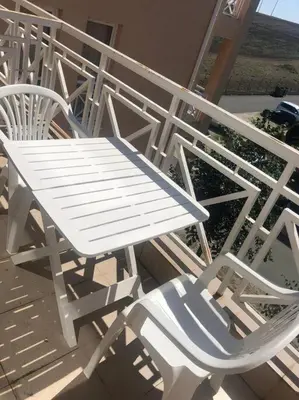 a white table and chairs sitting on a porch at Snug Studio Apt, Sunny Day 6 in Tŭnkovo