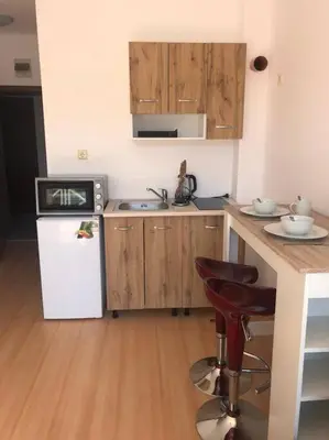 a kitchen with wooden cabinets and a white refrigerator at Snug Studio Apt, Sunny Day 6 in Tŭnkovo