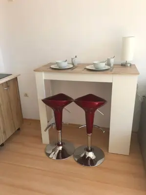 a table with two red stools in a room at Snug Studio Apt, Sunny Day 6 in Tŭnkovo