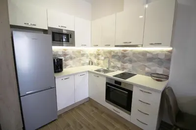 a kitchen with white cabinets and a sink and a refrigerator at Doris Beach studio D09 and studio D10 in Burgas City
