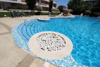 a swimming pool with rocks in front of a building at Doris Beach studio D09 and studio D10 in Burgas City