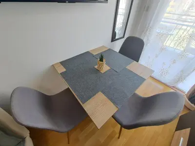a dining room table with chairs and a potted plant on it at Апартамент за гости Магнолия Резиденс in Sunny Beach