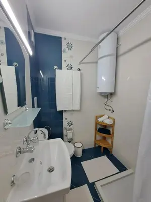 a bathroom with a white sink and a toilet at Апартамент за гости Магнолия Резиденс in Sunny Beach