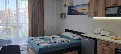 a room with a bed with towels on it at Апартамент за гости Магнолия Резиденс in Sunny Beach