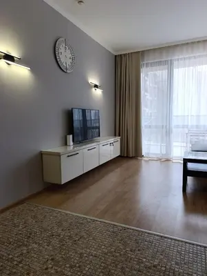 a living room with a television and a clock on the wall at Reina Apart Barcelo Beach in Sunny Beach