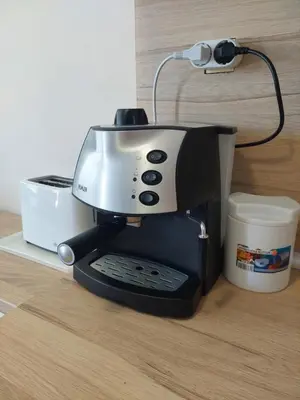 a black and white coffee maker next to a cup at Nereya Studio in Pomorie