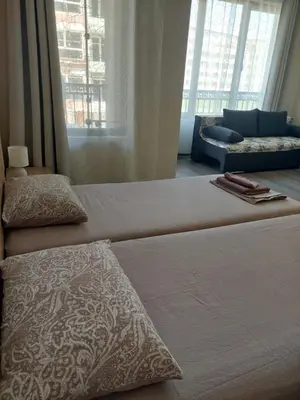 a bedroom with two beds and a couch and windows at Nereya Studio in Pomorie