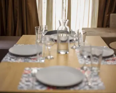 a wooden table with plates and glasses on it at Aleks Holiday-center,sea,parking in Burgas City