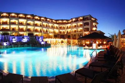 a large hotel with a swimming pool at night at Homely, 2 Bed Apt, 4* Vineyards in Kableshkovo
