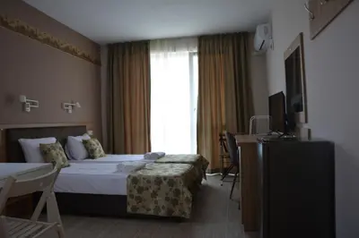 a hotel room with a bed and a window at Апартаменти Детелини in Primorsko