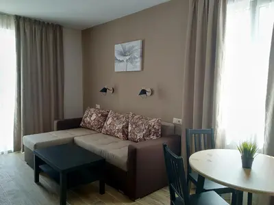a living room with a couch and a table at Апартаменти Детелини in Primorsko