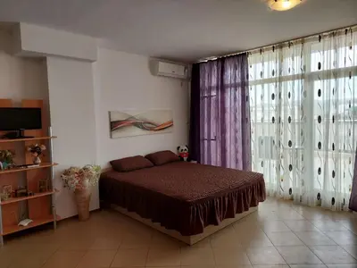 a bedroom with a bed and a large window at Солнечный берег Grand Kamelia in Sunny Beach
