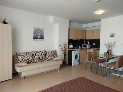 a living room with a couch and a table at Солнечный берег Grand Kamelia in Sunny Beach