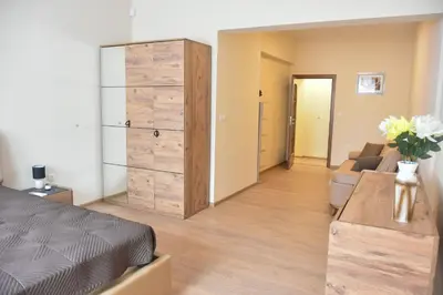a bedroom with a bed and a dresser and a couch at Trimaya apartment - comfort in the top city center in Varna City