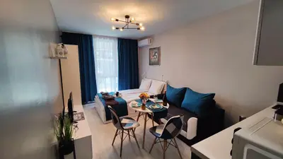 a living room with a couch and a table and chairs at Bayview Family Garden Studio A1 in Burgas City