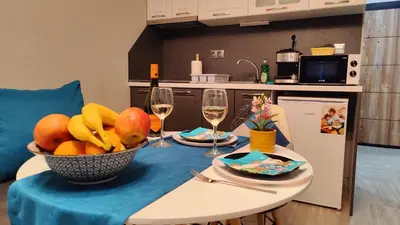 a table with a bowl of fruit and glasses of wine at Bayview Family Garden Studio A1 in Burgas City