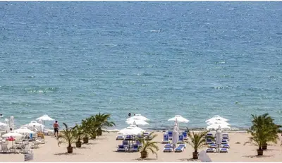a beach with chairs and umbrellas and the ocean at Bayview Family Garden Studio A1 in Burgas City