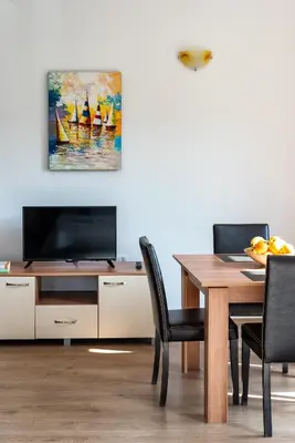 a dining room with a table and a painting of sailboats at Villa Entre in Emona