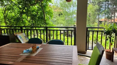 a wooden table and chairs on a porch with a view at Nevena Summer Apartment by Santa Marina Sozopol in Sozopol