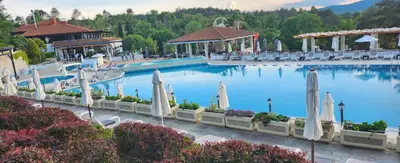 a large swimming pool with umbrellas in a resort at Nevena Summer Apartment by Santa Marina Sozopol in Sozopol