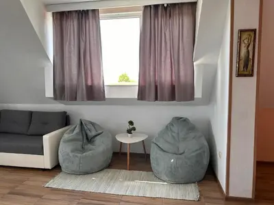 a living room with two gray ottomans and a couch at Your Room Primorsko in Primorsko