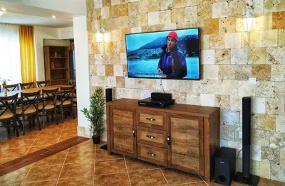 a living room with a tv on a stone wall at Villa Meraki in Byala
