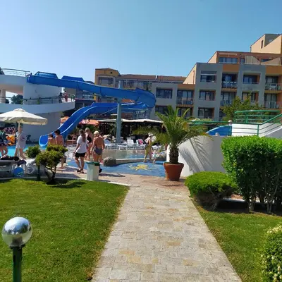 a pool with a slide and people in a resort at Trakia Plaza Apartament Sunny Beach in Sunny Beach