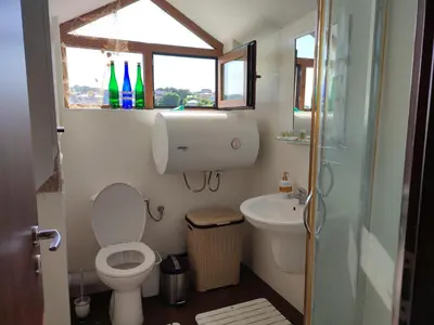a bathroom with a toilet and a sink and a window at Созополски Рай in Sozopol