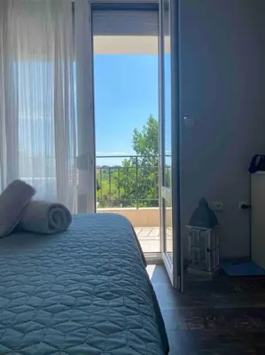 a bedroom with a bed and a sliding glass door at Nessebar panoramic apartment in Nesebar