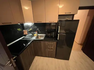 a kitchen with a black refrigerator and a sink at Vqra Sarafovo in Burgas City