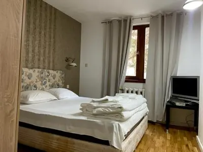 a bedroom with a bed and a television in it at Apart Zefira 2 Rooms in Varna City