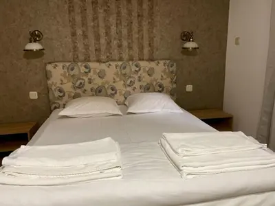 a white bed with two white towels on it at Apart Zefira 2 Rooms in Varna City
