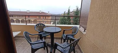 a table and four chairs on a balcony with a view at Чудесно място с басейн 