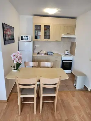 a kitchen with a table and chairs and a kitchen with a table and a kitchen at Modern 1 Bed Apt, Nesebar Fort in Sunny Beach