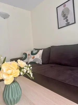 a living room with a couch and a vase with flowers at Green Central Apartment in Varna City