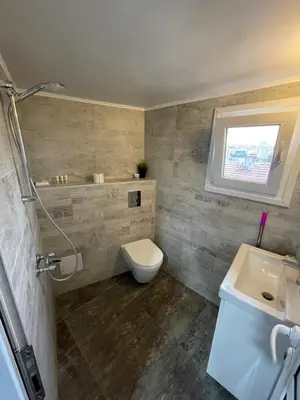 a bathroom with a toilet and a sink and a window at Studio flat in the heart of Burgas in Burgas City