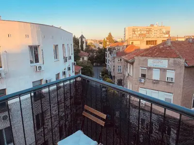 a bench sitting on top of a balcony with buildings at Studio flat in the heart of Burgas in Burgas City