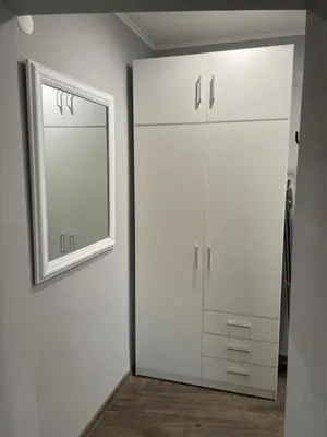 a white closet with a mirror on the wall at Studio flat in the heart of Burgas in Burgas City