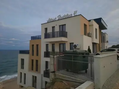 a building on the beach next to the ocean at Diamond Beach Luxus Apart Obzor 28 in Obzor
