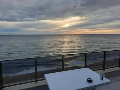 a white table on a balcony looking at the ocean at Diamond Beach Luxus Apart Obzor 28 in Obzor
