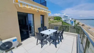 a patio with a table and chairs on a balcony at Diamond Beach Luxus Apart Obzor 28 in Obzor