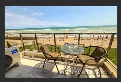 a balcony with a table and chairs and a beach at Diamond Beach Luxus Apart Obzor 28 in Obzor